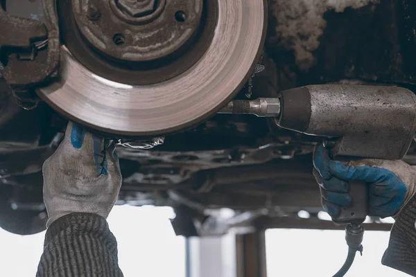 Mains de mécanicien automobile dans le service de réparation automobile. — Photo