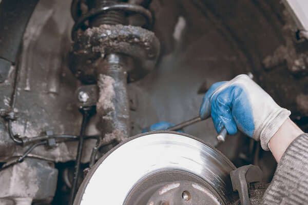 Hands of car mechanic in auto repair service.