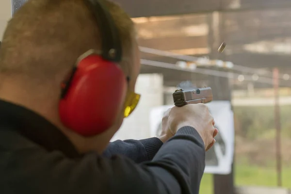 Strzelanie z pistoletu. Mężczyznę strzelającego pistolet w strzelnicy. — Zdjęcie stockowe