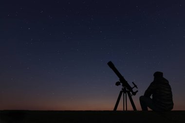 Astronomi teleskopuyla yıldızlara bakarak adam. 