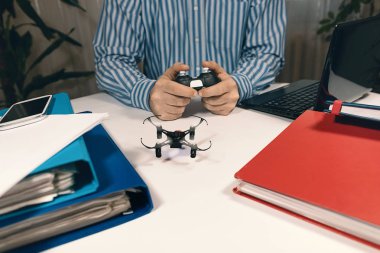İşyerinde stres rahatlatmak için dron oyuncakla oynarken işadamı.