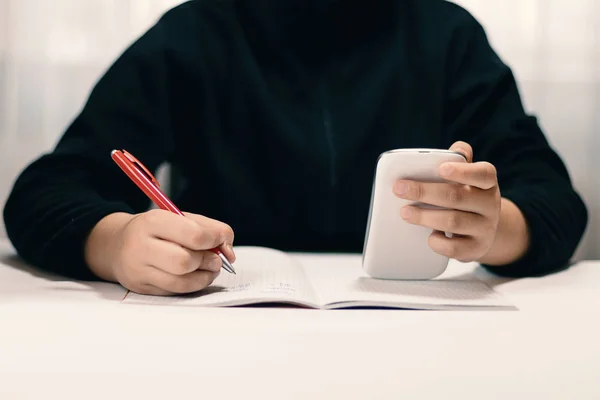 Jongen met smartphone huiswerk. Leren concept. — Stockfoto