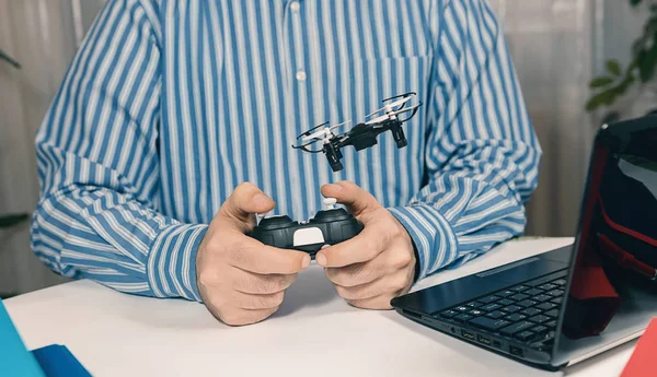 Geschäftsmann spielt mit Drohnenspielzeug, um Stress bei der Arbeit abzubauen. — Stockfoto