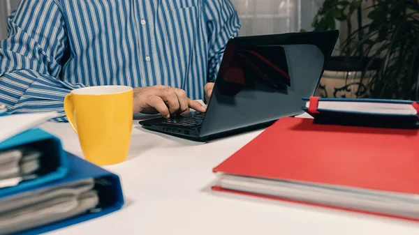 Man zit bij balie werken met laptop vanuit huis — Stockfoto