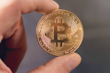 Altın Bitcoin sanal para tutan el.