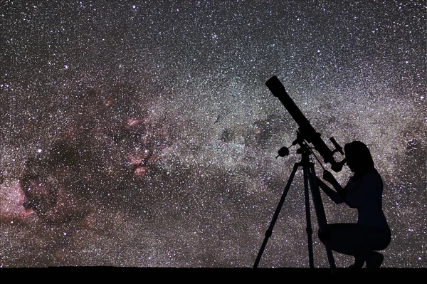 Fata se uită la stele cu telescop. galaxia Calea Lactee . — Fotografie, imagine de stoc