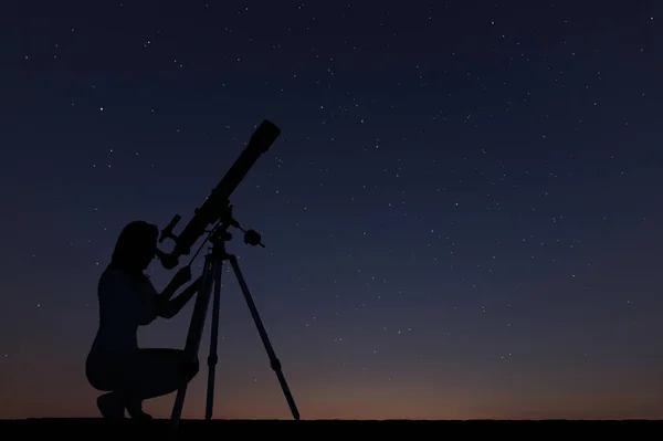 Το κορίτσι κοιτάζοντας τα αστέρια με τηλεσκόπιο. Έναστρο ουρανό τη νύχτα — Φωτογραφία Αρχείου