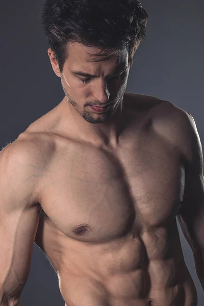 Guapo sin camisa musculoso joven sobre fondo oscuro —  Fotos de Stock