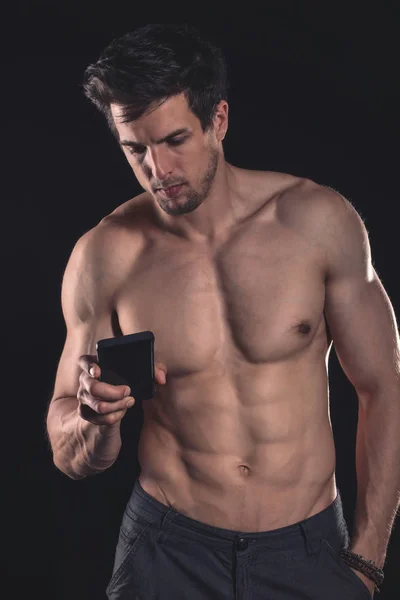 Guapo sin camisa musculoso joven usando el teléfono celular — Foto de Stock