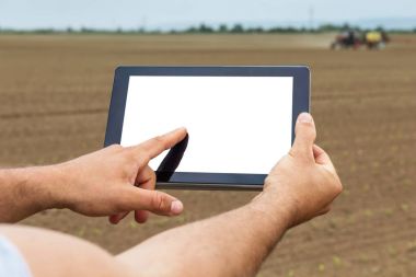 Çiftçi tarımsal ekili alandaki tablet bilgisayar kullanarak. W