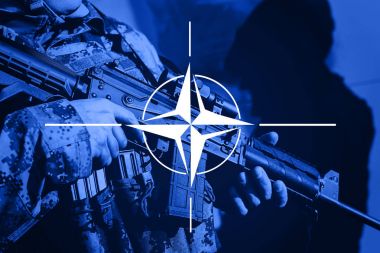 Asker makineli tüfek ile Nato İttifak bayrağı ile
