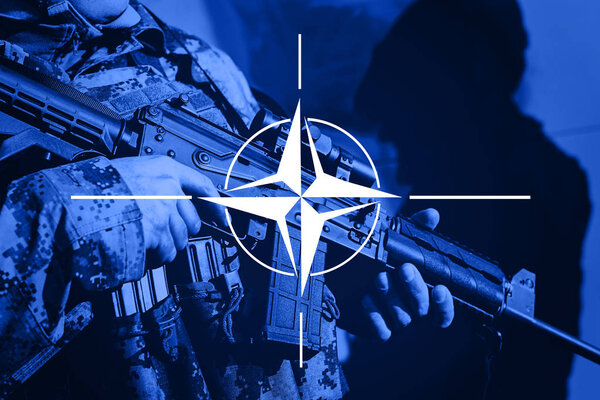 Soldier with machine gun with flag of NAtO Alliance