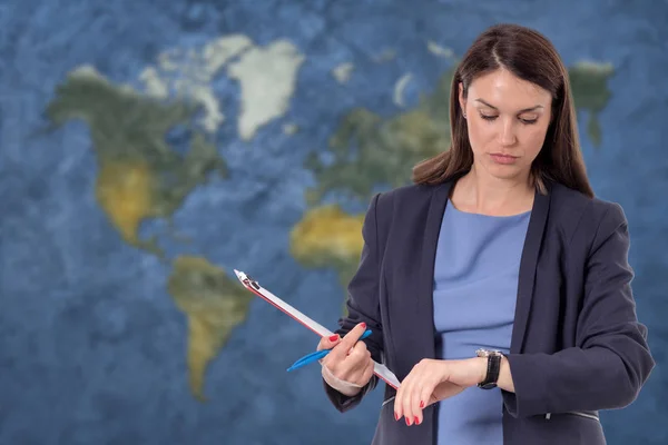 Mulher de negócios a olhar para o relógio. Mapa do mundo conceito de globalização — Fotografia de Stock