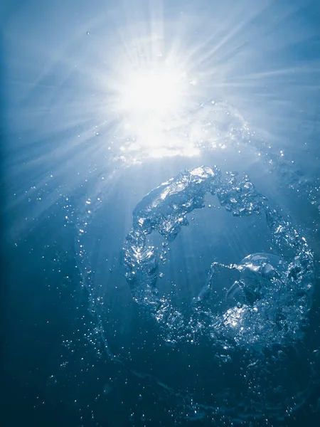 Bubble ring underwater ascends towards the sun. — Stock Photo, Image