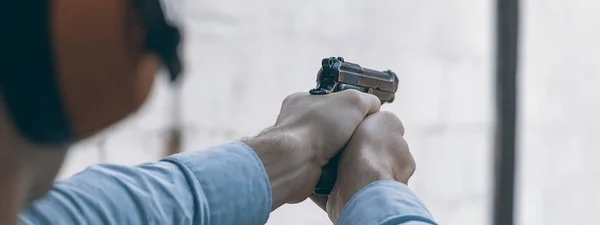 Strzelanie z pistoletu. Człowieka, mające pistolet w strzelnicy. — Zdjęcie stockowe