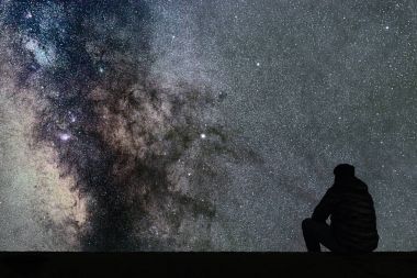 Samanyolu. Gece gökyüzünde yıldızlar ve siluet yalnız adam arıyorum