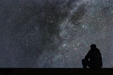 Samanyolu. Gece gökyüzünde yıldızlar ve siluet yalnız adam arıyorum