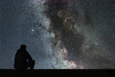 Samanyolu. Gece gökyüzünde yıldızlar ve siluet yalnız adam arıyorum