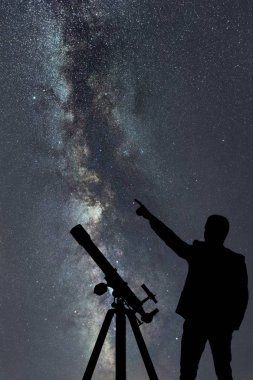 Samanyolu. Gece gökyüzünde yıldızlar ve ayakta adam silüeti