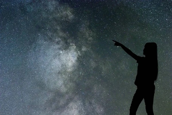 Silhouette of woman stand alone in the night milky way and stars