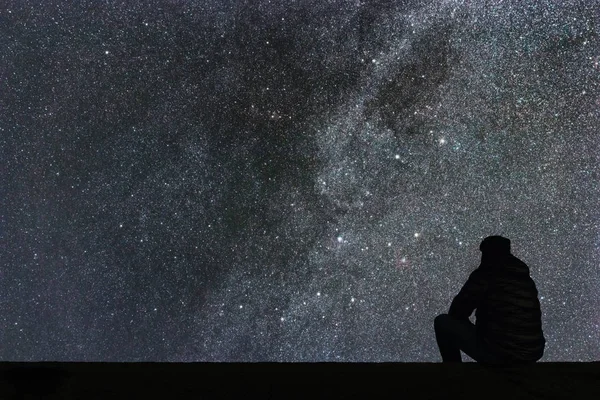 Samanyolu. Gece gökyüzünde yıldızlar ve siluet yalnız adam arıyorum