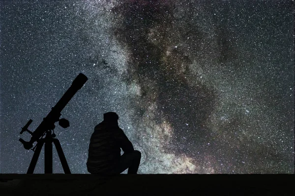 Чоловік дивиться на зірки астрономія телескоп. Чумацький шлях зоряне — стокове фото