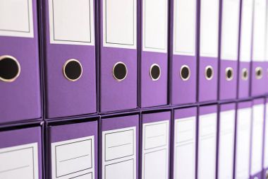 Ciltçi klasörlerde raf, bağlayıcılar üst üste. 