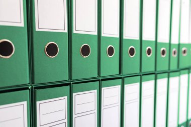 Ciltçi klasörlerde raf, bağlayıcılar üst üste. 