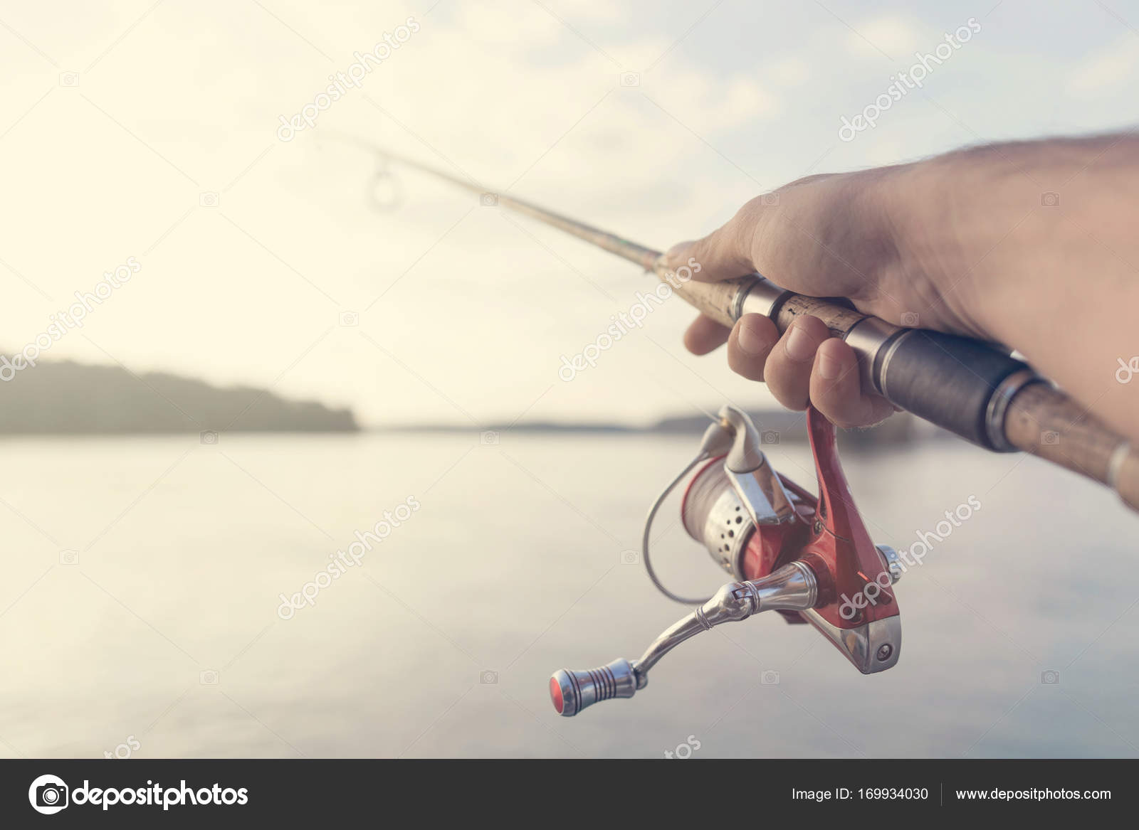 Fishing rod and reel hand holding. Shallow depth of field — Stock Photo ©  Allexxandar #169934030