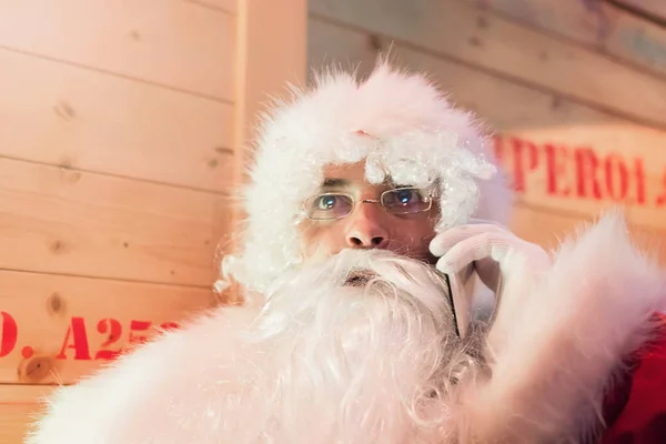 Santa Claus rozmowy na telefon komórkowy w magazynie. — Zdjęcie stockowe