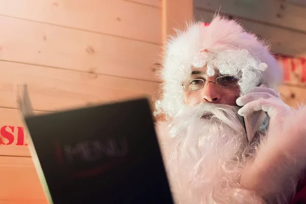 Santa Claus rozmowy na telefon komórkowy w restauracji. — Zdjęcie stockowe