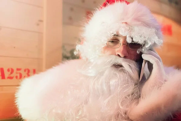 Santa Claus rozmowy na telefon komórkowy w magazynie. — Zdjęcie stockowe