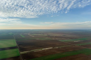 Havadan görünümü bulutlar üzerinde yeşil tarım alanları üzerinde.