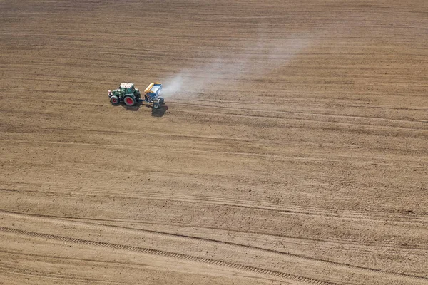 Tractor fertilizing field, Aerial View. Tractor spreading artifi