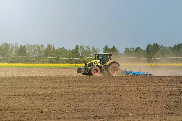 Petani di traktor mempersiapkan penanaman benih tanah. Pertanian — Stok Foto