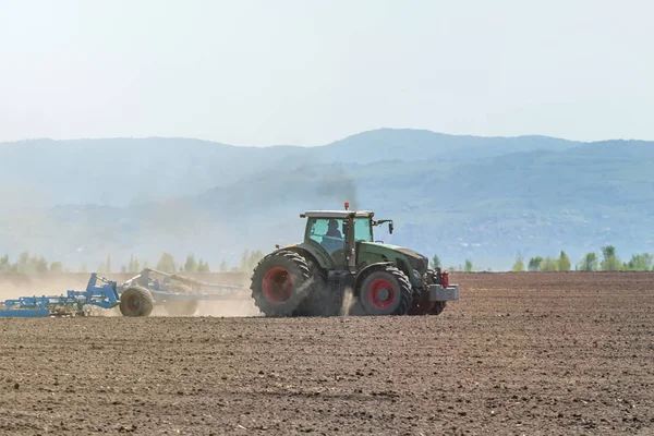 Boer in trekker land voedingsbodem frees voorbereiden. Landbouw — Stockfoto