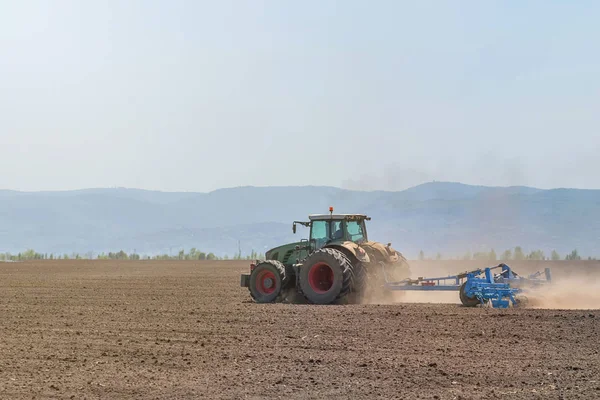 Petani di traktor mempersiapkan penanaman benih tanah. Pertanian — Stok Foto