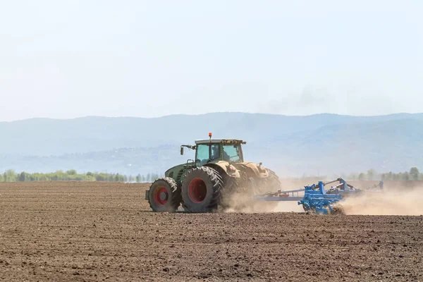 Petani di traktor mempersiapkan penanaman benih tanah. Pertanian — Stok Foto