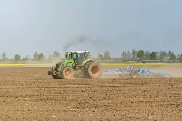 Petani di traktor mempersiapkan penanaman benih tanah. Pertanian — Stok Foto