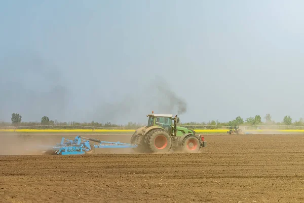 Petani di traktor mempersiapkan penanaman benih tanah. Pertanian — Stok Foto