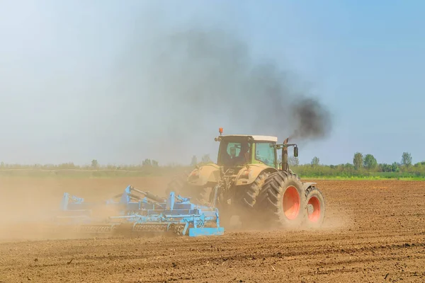 Boer in trekker land voedingsbodem frees voorbereiden. Landbouw — Stockfoto
