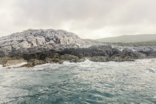 Zee landschap golven crashen tegen de rotsachtige kustlijn, bewolkt — Stockfoto