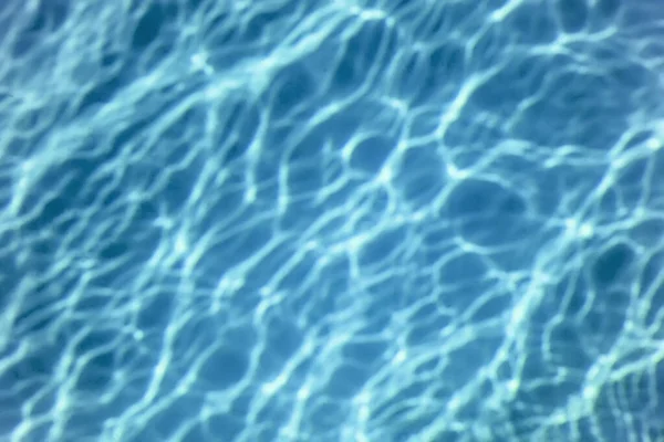 Schwimmbadwasser. Wellenwasser. Sonnenreflexion Hintergrund. — Stockfoto