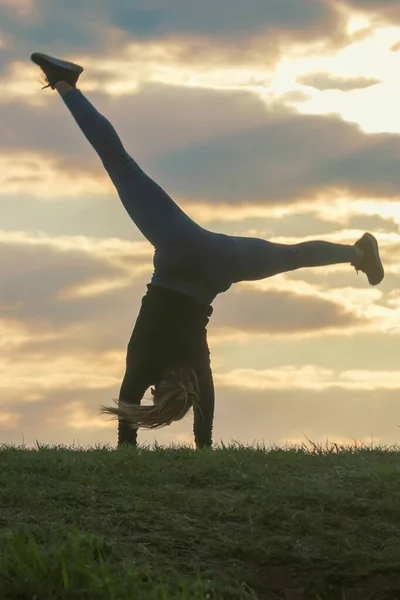 Jovem mulher fazendo cartwheel na grama Manhã treino beautif — Fotografia de Stock