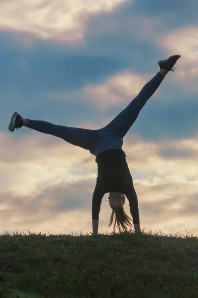 Jovem mulher fazendo cartwheel na grama Manhã treino beautif — Fotografia de Stock