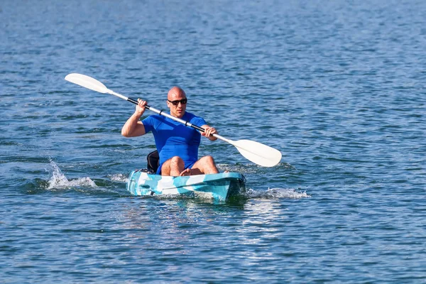 El joven Kayaker remando Kayak. Deportista kayak Blue Water . — Foto de Stock