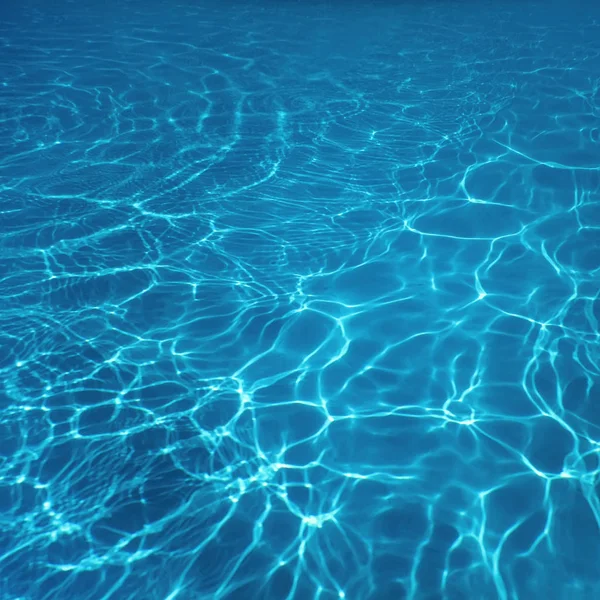 Piscina acqua sole riflesso sfondo. Ondulazione dell'acqua. — Foto Stock