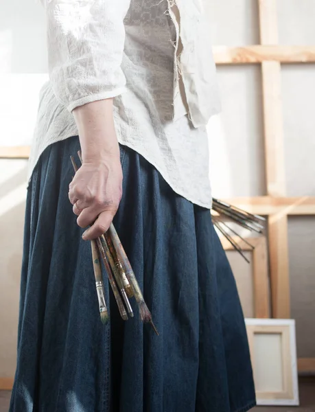 Mulher artista segurando pincéis — Fotografia de Stock