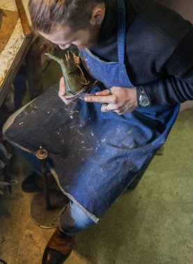 Erkek ayakkabıcı çalışıyor. 