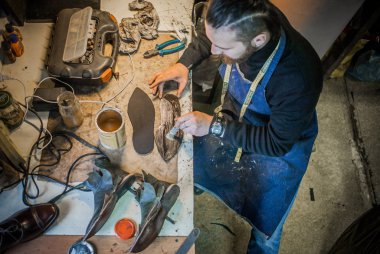 Erkek ayakkabıcı çalışıyor. 